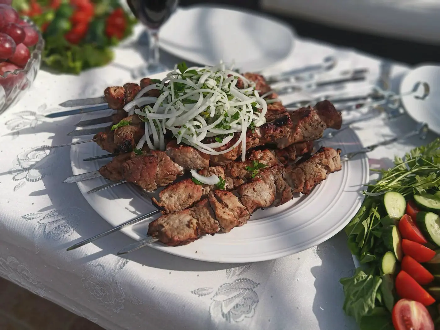 Gegrilltes Fleisch vom Spieß mit Beilagen auf dem Teller.